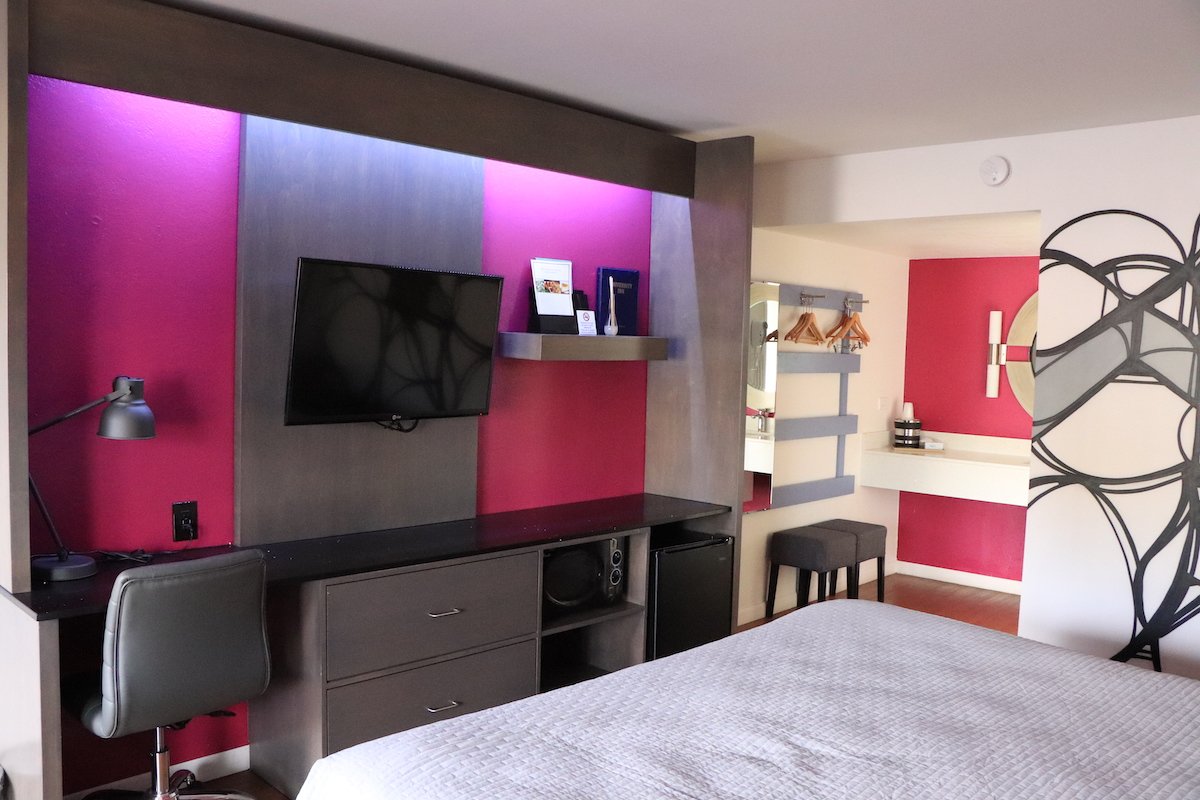 1 King Bed — TV entertainment center with ambient lighting and vanity mirror