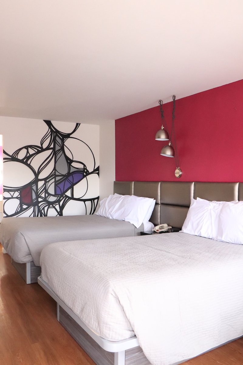 2 Double Beds — red accent wall with two beds