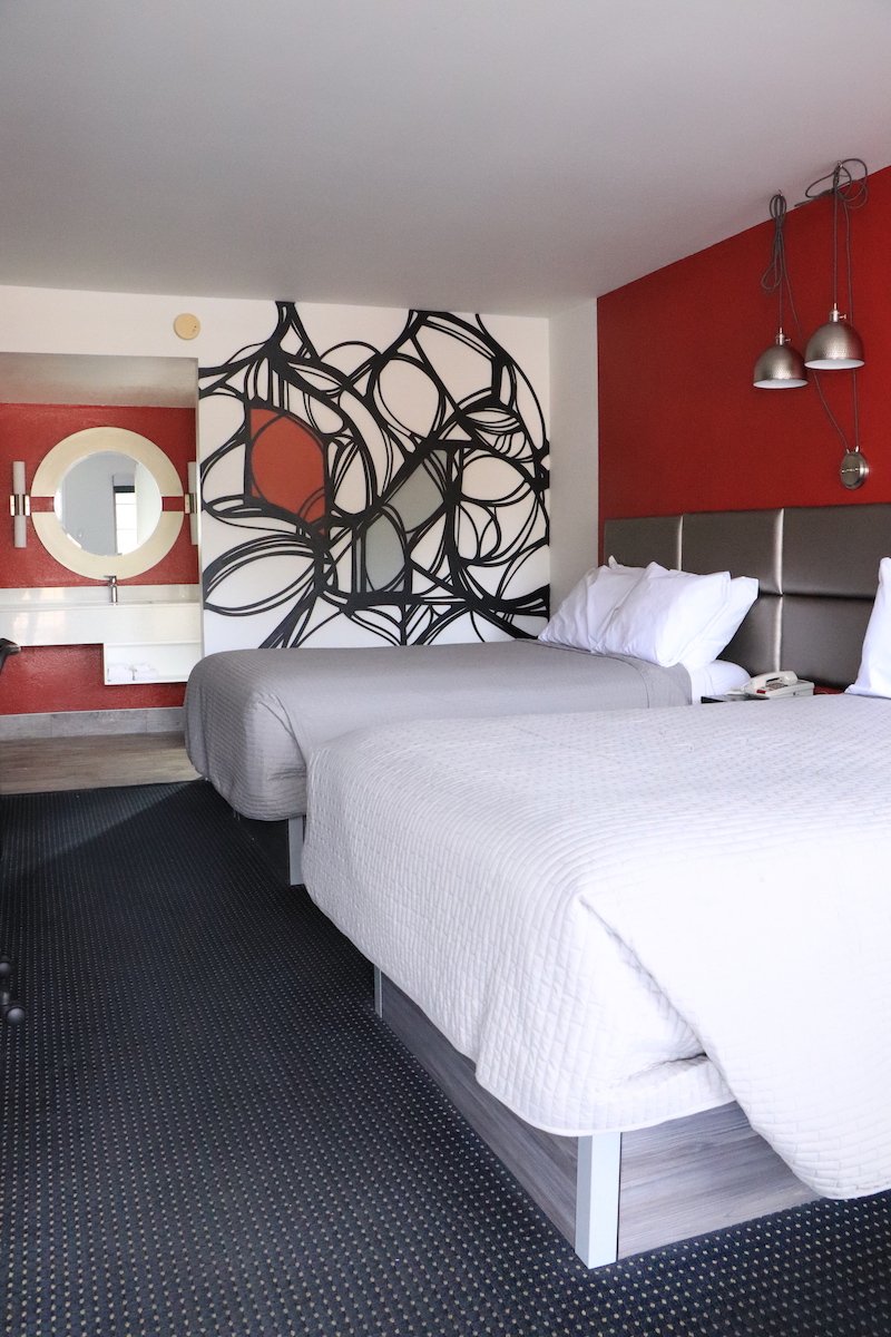 2 Double Beds — red accent wall with vanity mirror